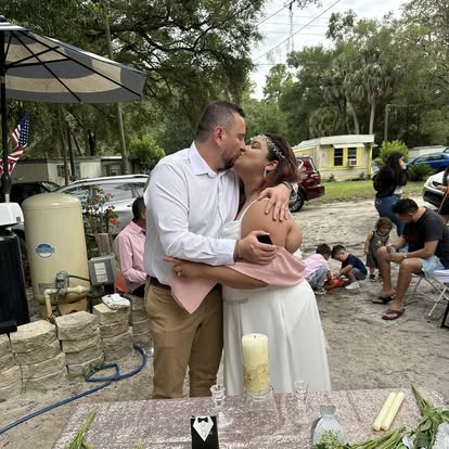 A couple kissing at their outdoor celebration