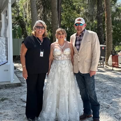 Esther with a wedding couple beside a stone fountain