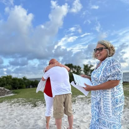 Esther at a beach ceremony beneath a dramatic evening sky