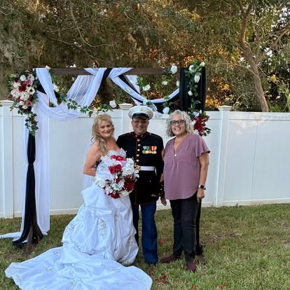 Wedding party beside white drapery and flowers