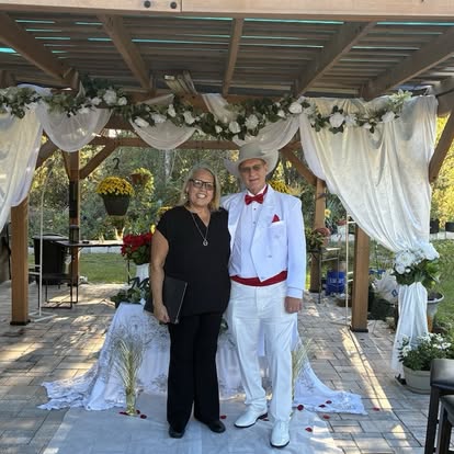 Esther with newlyweds beneath white wedding drapery