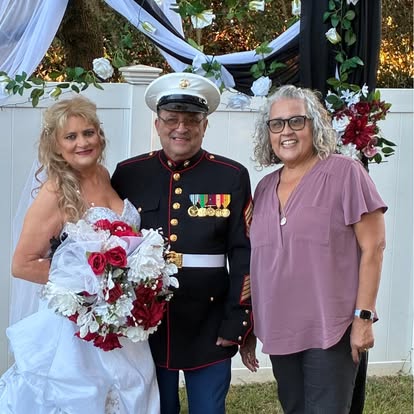 Esther with newlyweds and a red bridal bouquet